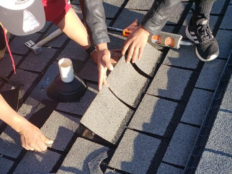 Roofers installing shingles